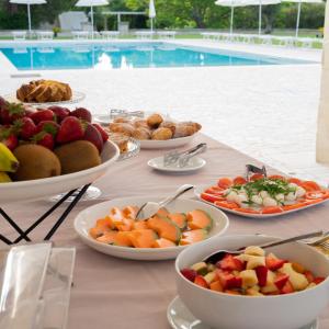 stół z talerzami owoców i wypieków przy basenie w obiekcie La Casina Di Borgagne w mieście Borgagne