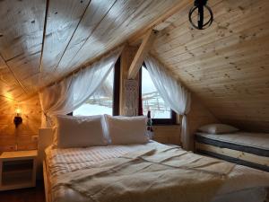 a bedroom with a bed in a wooden house at Refugiul din Vama in Vama Buzăului +12 photos