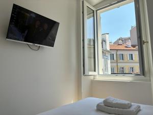 a bedroom with a tv and a bed and a window at Il Sigillo in Trieste
