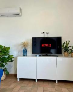 a tv sitting on top of a white cabinet at Sea Breeze House in Fiumicino +36 photos