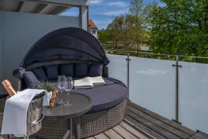 einem Korbstuhl auf einer Terrasse mit einem Tisch in der Unterkunft Boutiquehotel zur Winzerstube - Adults Only in Hagnau