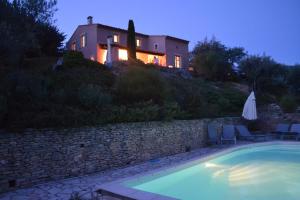 a villa with a swimming pool in front of a house at Villa Pialats in Buis-les-Baronnies