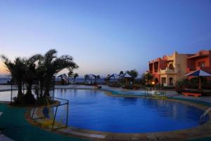 a large swimming pool with palm trees in a resort at Tropitel Dahab Oasis in Dahab