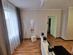 a living room with a table and a large window at Pīlādži in Liepāja