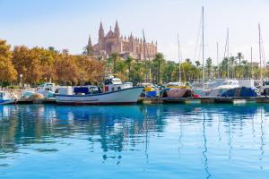 a group of boats docked in a harbor with a church at 272 Casa Sol ETV7727 by Mallorca Charme in Can Picafort
