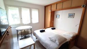 ein kleines Schlafzimmer mit einem Bett und einem Tisch in der Unterkunft VK Ocean in Mimizan