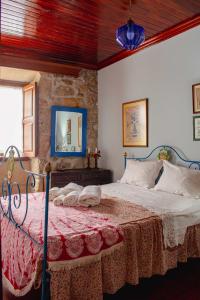 - une chambre avec un lit et une couverture rouge dans l'établissement Casa das Fontes, à Ponte da Barca