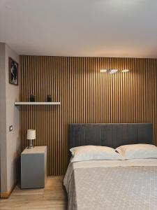 ein Schlafzimmer mit einem Bett und einer gestreiften Wand in der Unterkunft Catanese Proverb's House - Via Napoli in Catania