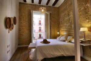 a bedroom with a bed with a hat on it at Apartamentos Almada - calle Alfonso - Plaza SAS in Zaragoza