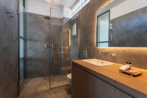 a bathroom with a sink and a shower at Above Blue two Bedroom Villa in Plomarion +21 photos