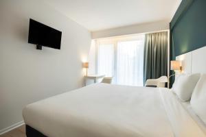 布魯塞爾的住宿－Hotel Louise，酒店客房设有一张白色大床和一个窗户。