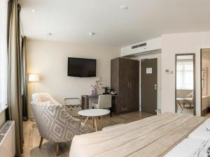 a hotel room with a bed and a table and chairs at Het Wapen van Elst in Elst