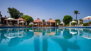 una piscina in un resort con sedie e ombrelloni di Umm Al Quwain Beach Hotel a Umm Al Quwain