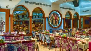 فندق شاطئ أم القوين في أم القيوين: غرفة طعام مع طاولات وكراسي في مطعم