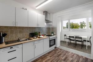 a kitchen with white cabinets and a table with chairs at Ferienwohnung Arkadia Zentrale in Norderstedt