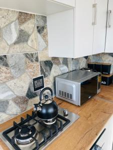 a tea kettle on a stove top in a kitchen at Makgobelo Lodge-The Glass House- Solar powered in Ga-Mokalapa