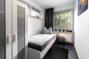 a small room with a bed and a window at Ferienwohnung Arkadia Zentrale in Norderstedt