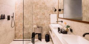 un bagno con doccia, lavandino e specchio di Hotel Hohenwart a Scena