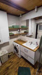 a kitchen with a sink and a washing machine at Domek w Sadzie in Marcinowa Wola