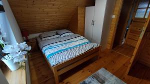 a bedroom with a bed in a wooden room at Domek w Sadzie in Marcinowa Wola