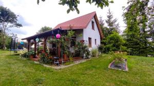 a small house in a field with a yard at Domek w Sadzie in Marcinowa Wola