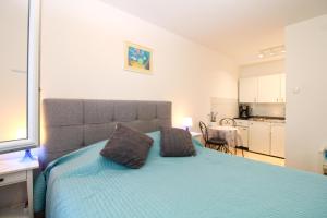 - une chambre dotée d'un lit bleu avec deux oreillers dans l'établissement Apartment Marija 1387, à Fažana