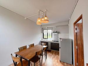 a kitchen and dining room with a wooden table and chairs at Moonlit Khaoyai in Ban Tha Wua Tai