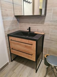 Cuxac-dʼAudeにあるAppartement rénové avec jardinの黒い洗面台と鏡のあるバスルーム