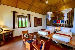 - une chambre avec 2 lits, une table et un bureau dans l'établissement Puluong Retreat, à Pu Luong