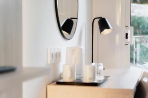 a table with a mirror and a lamp on it at Minura Cala Galdana & Apartamentos d'Aljandar in Cala Galdana