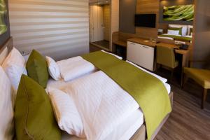 a bedroom with a large bed with a desk and a kitchen at BH Kristály in Debrecen