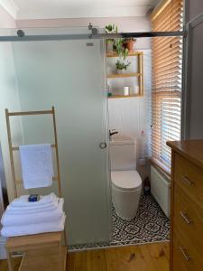 a bathroom with a toilet and a glass shower door at Herne Bay Central - 2 minutes from beach apartment in Herne Bay +36 photos