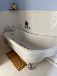 a white bath tub sitting in a bathroom at Herne Bay Central - 2 minutes from beach apartment in Herne Bay