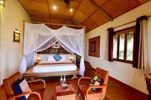 a bedroom with a large bed with a canopy at Puluong Retreat in Pu Luong
