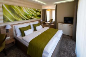 a bedroom with a large bed and a television at BH Kristály in Debrecen