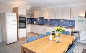 a kitchen with a wooden table and blue tiles at At Watersedge in Exmouth