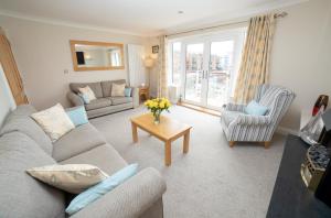 a living room with a couch and a table at At Watersedge in Exmouth