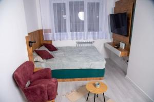 a small bedroom with a bed and a chair at Prishtina's Finest in Pristina