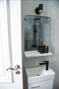 a white bathroom with a sink and a mirror at Prishtina's Finest in Pristina