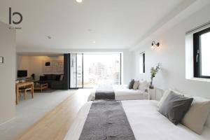 een witte woonkamer met een bed en een bank bij bHOTEL heiwaodori, Room: 901 - Vacation STAY 17680v in Hiroshima