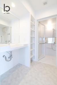 een witte badkamer met een wastafel en een douche bij bHOTEL heiwaodori, Room: 901 - Vacation STAY 17680v in Hiroshima