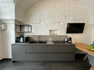 eine Küche mit Spüle und weißer Ziegelwand in der Unterkunft Star White in Ostuni