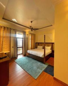 a bedroom with a bed and a large window at Devnadi Hotel in Haridwār