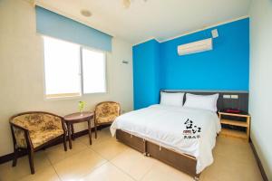 北竿鄉的住宿－台江大飯店，卧室配有一张床和一张桌子及椅子