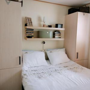 a small bedroom with a bed and two pillows at Rapunzel in Laag-Soeren