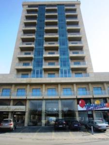 een hoog gebouw met auto's geparkeerd voor het bij Boutique Hotel in Beiroet