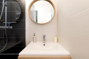 La salle de bains est pourvue d'un lavabo et d'un miroir. dans l'établissement Point d'Or, à Hossegor