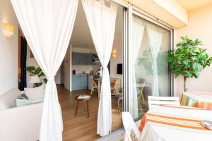 a bedroom with white curtains and a living room at Point d'Or in Hossegor
