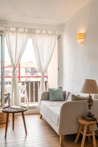 a living room with a couch and a large window at Point d'Or in Hossegor