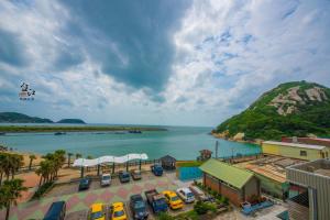 un gruppo di auto parcheggiate accanto a un corpo idrico di Taijing Hotel a Beigan